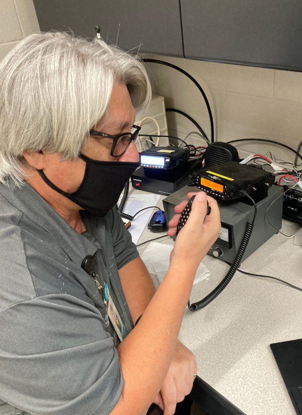 blaine fergerstrom sits in front of a ham radio station while transmitting a message during hurricane douglas in July 2020