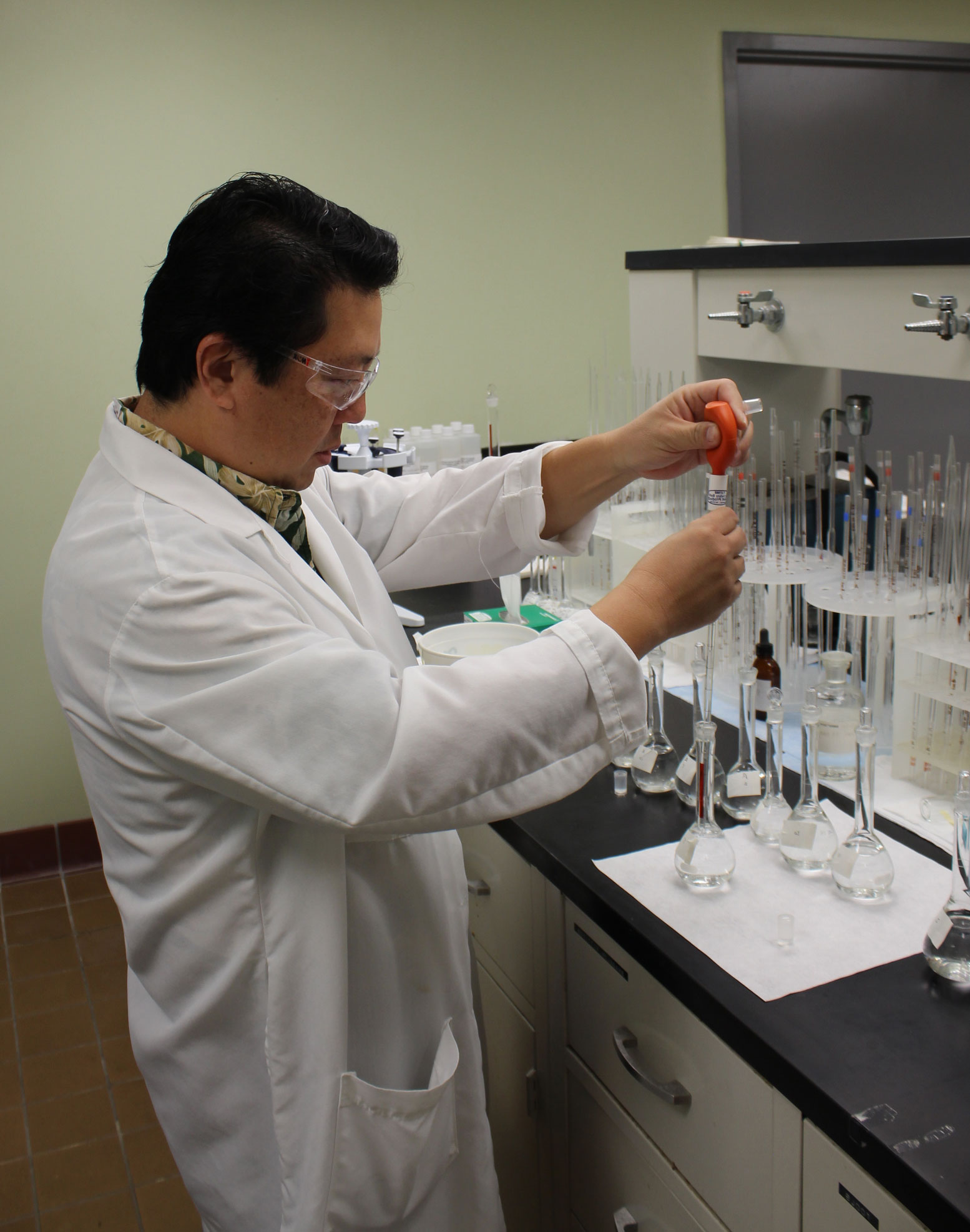lab technician conducting a water quality test with a beaker in 2017
